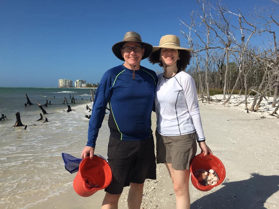 Guests holding up buckets full of seashells found on the tour